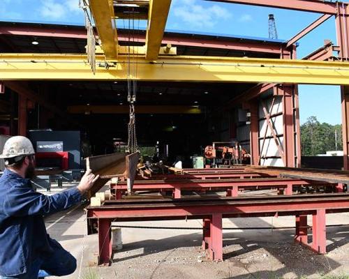 Overhead crane system handling I-beams at the 澳门足彩app Steel Shop